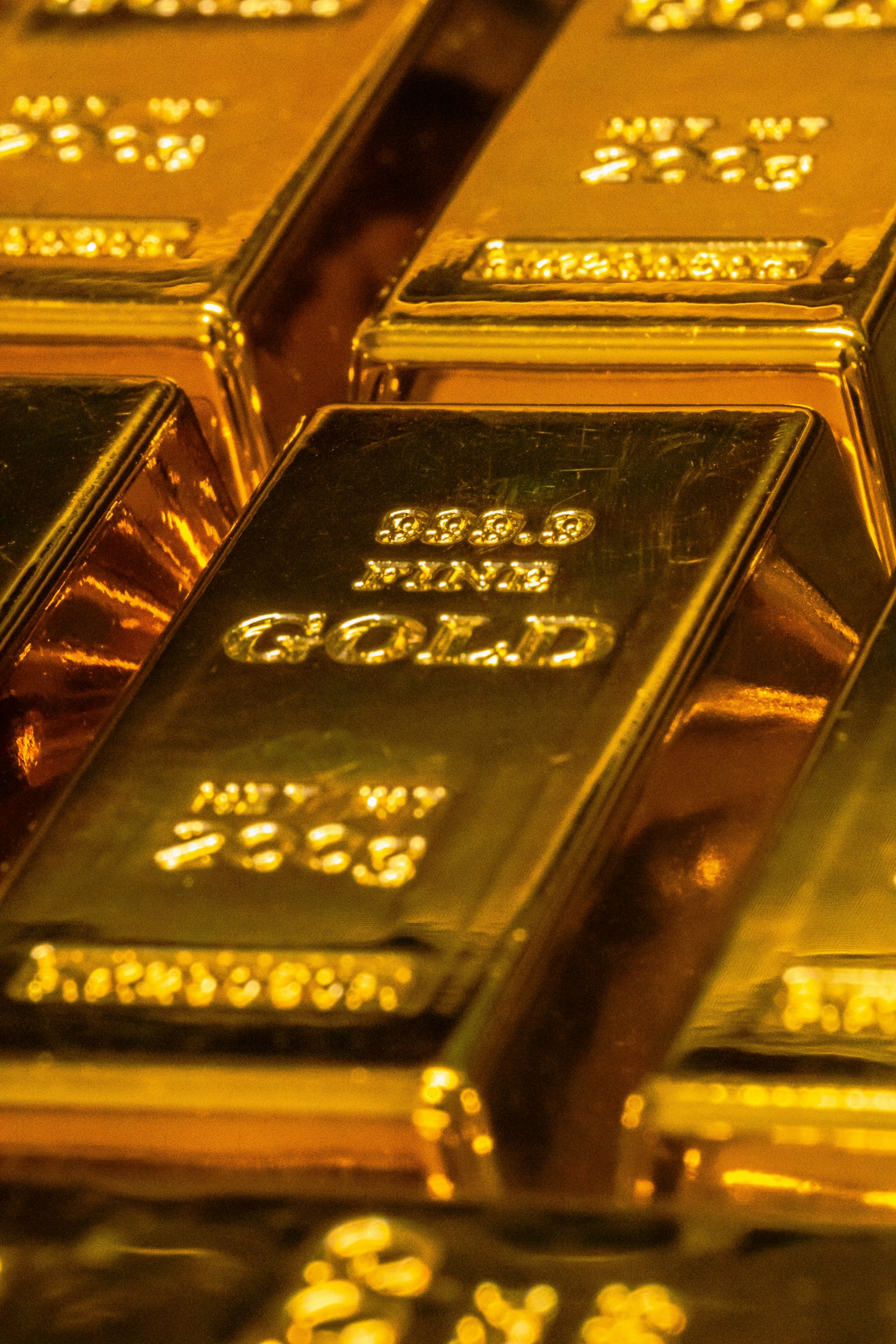 Lingotes de oro de cerca, con el sello de pureza grabado: lo verificable se puede leer; lo demás es brillo.